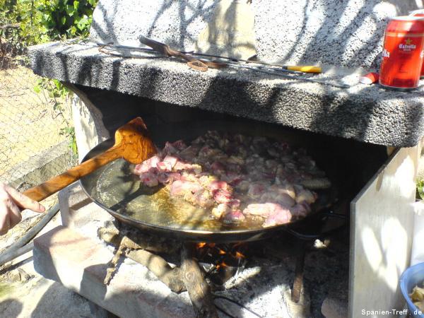 Anbraten von Fleisch in Olivenöl in der Paella