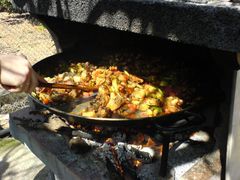 Hinzufügen von Tomaten und Paprika zur Paella