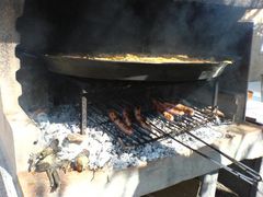 Bratwürste/Salchichas unter der Paella wenden