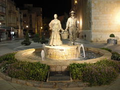 Brunnen mit zwei Figuren die einenKorb voller Artischocken halten