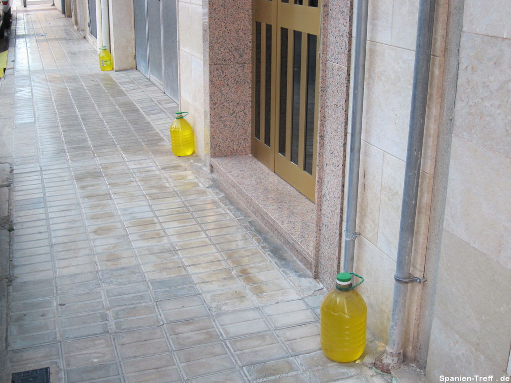 Flaschen mit gelber Flüssigkeit an Häusern gegen Hundeurin