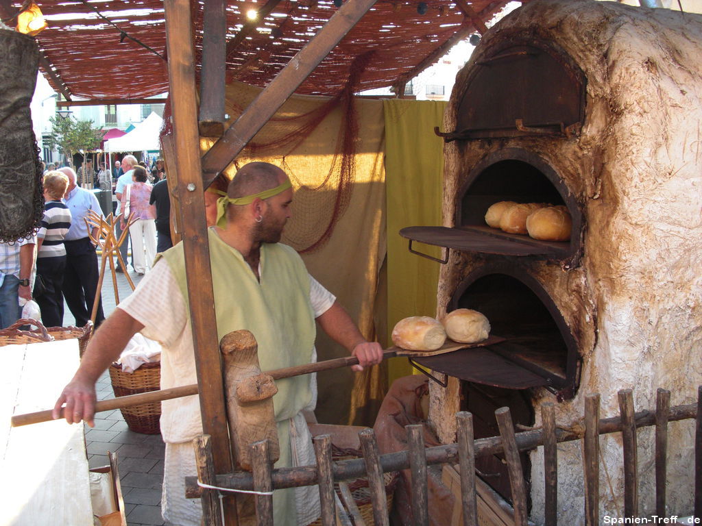 Bäcker schiebt auf dem Markt, Brot in den Ofen.