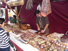 Wurstwaren am Marktstand und Mann in altertümlicher Kleidung